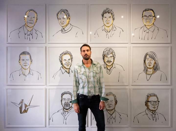 Niklas Elmehed; standing in front of other Nobel Prize Laureates official portraits he designed 