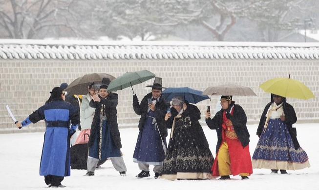 Foreign tourists wearing Hanbok take photos amid heavy snow