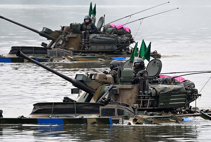 Amphibious light tank K21 crosses river for drill