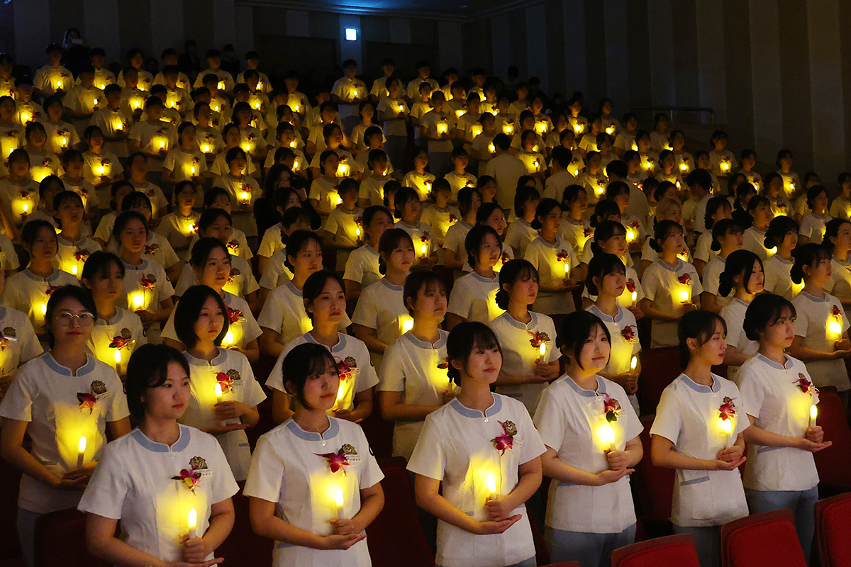 Sophomore nursing majors at the Medical Campus of Gacheon University in Incheon's Yeonsu-gu District on the afternoon of Nov. 8 hold candles at the school's 77th Nightingale Pledge ceremony.